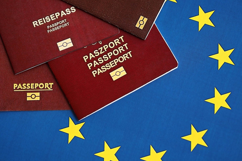 Passaportes dos países da União Europeia na bandeira azul da UE de perto. Passaportes de Portugal, alemão, francês e polonês