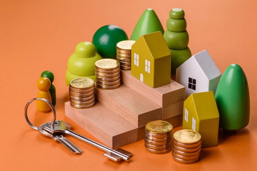Composição conceitual de degraus de madeira com moedas, modelo de uma casa como o crescimento dos investimentos financeiros em imóveis